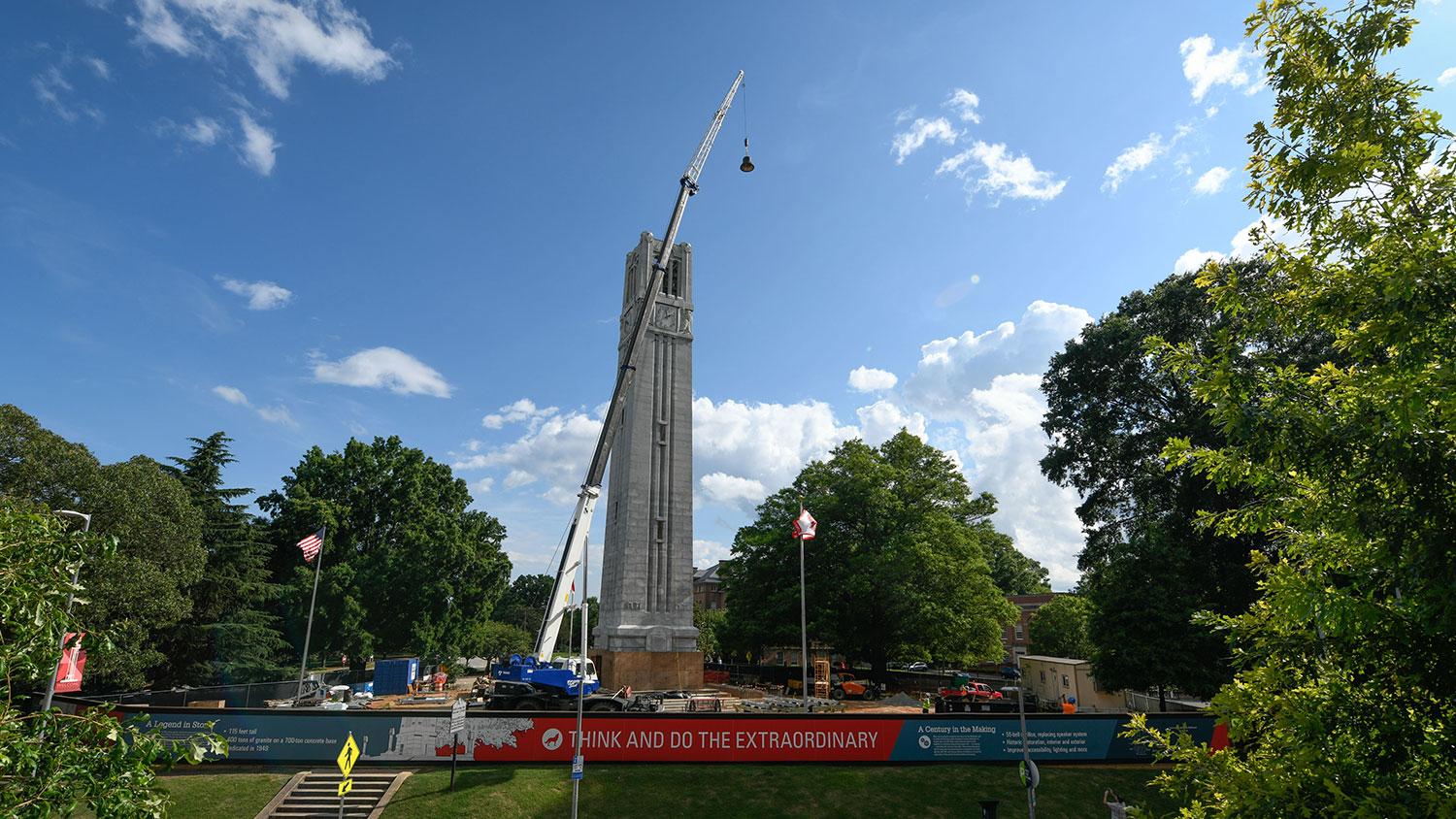 A crane holding a bell to be installed in the top of the Belltower.