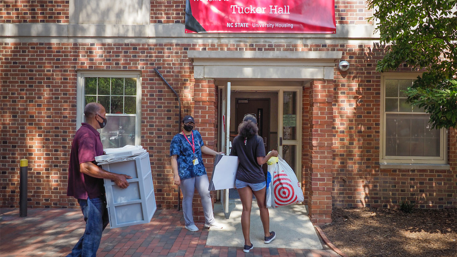 A student and parents carry their belongings into Tucker Hall