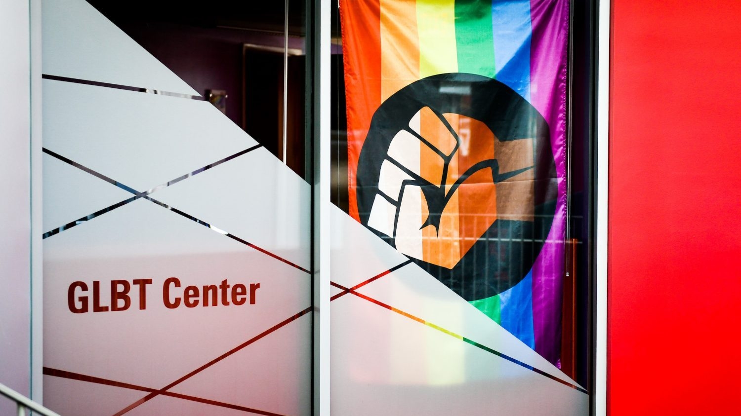 exterior shot of the GLBT center doors with the pride flag with raised fist hanging