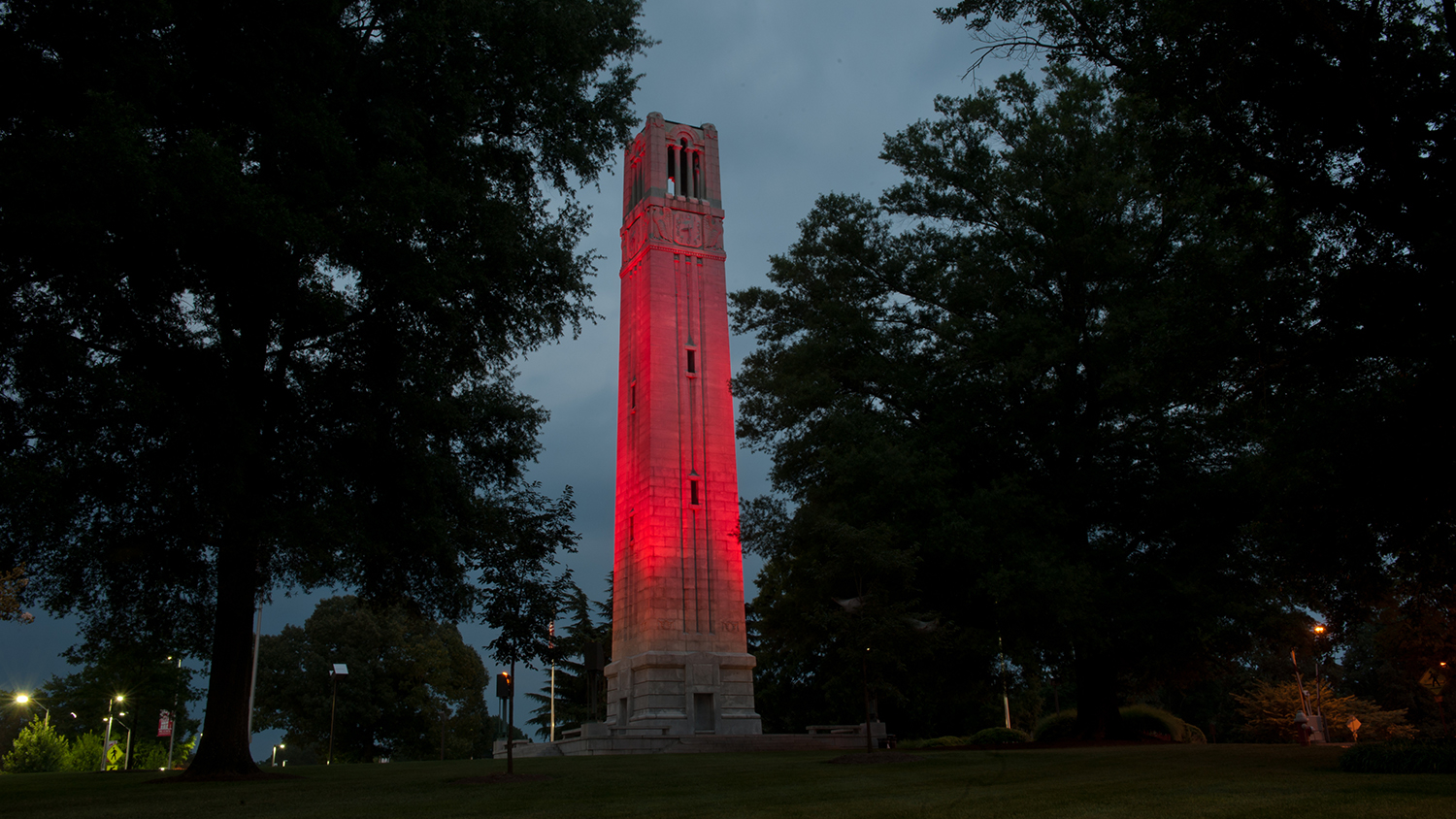 The belltower illuminated in red at dusk