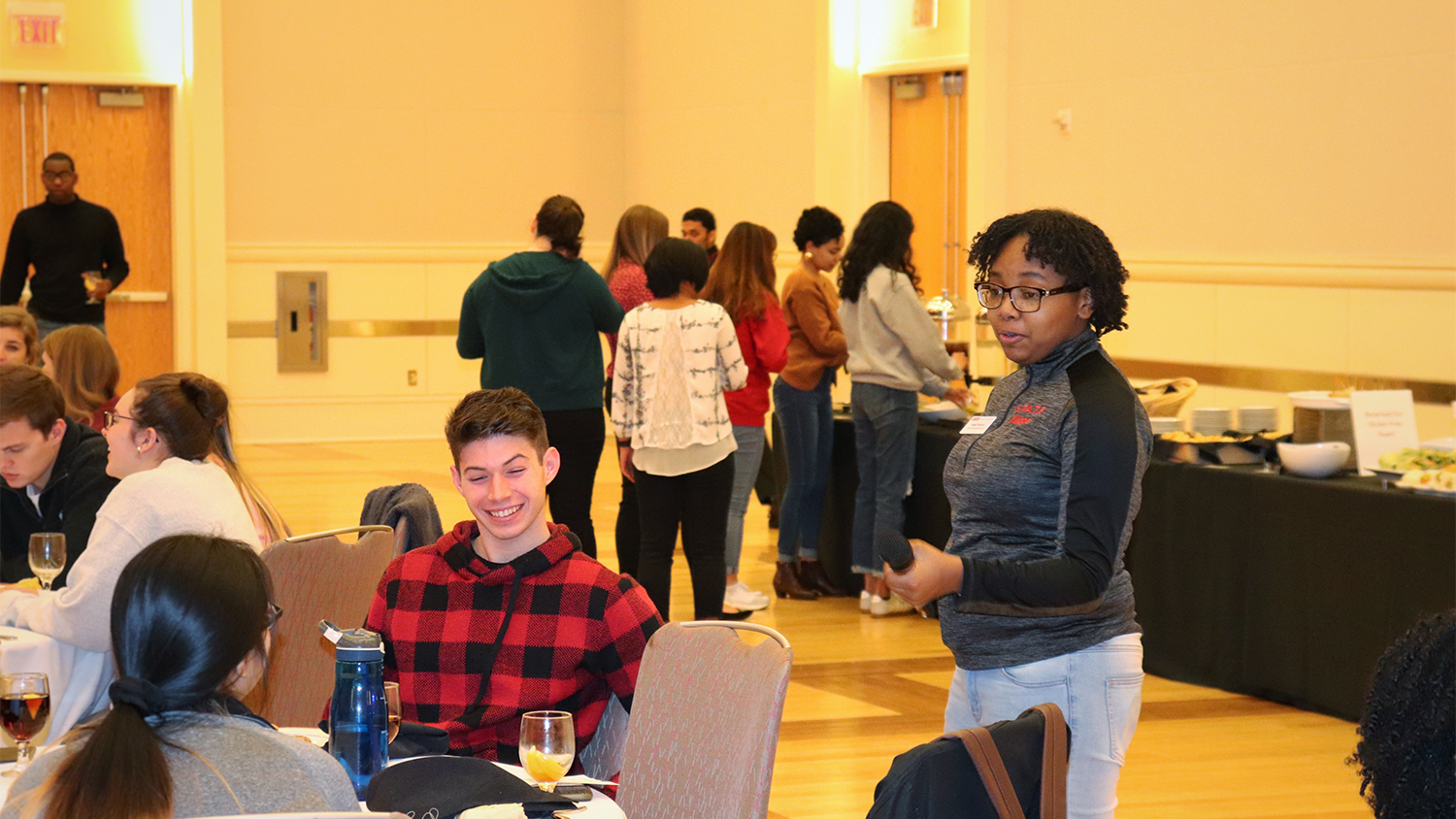 Sade Proctor speaks to students at a table during a career workshop
