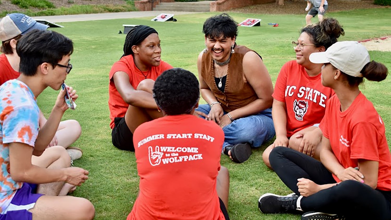 Students participating in Summer Start sit in a circle on the lawn outside of Tucker Hall and socialize during a Summer Start event.