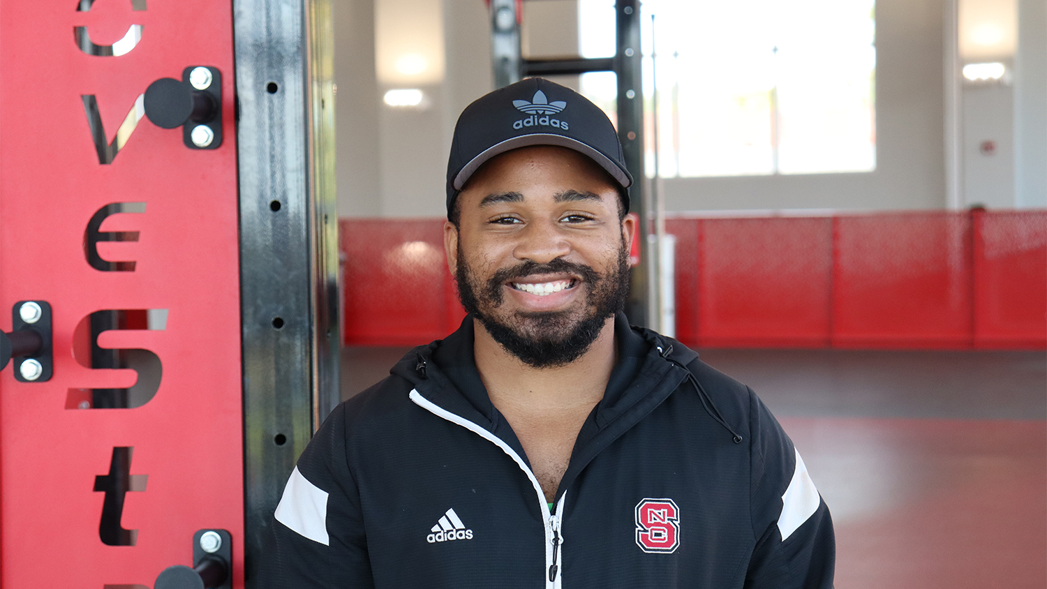 Jerick Garrett in a black NC State jacket and Adidas hat