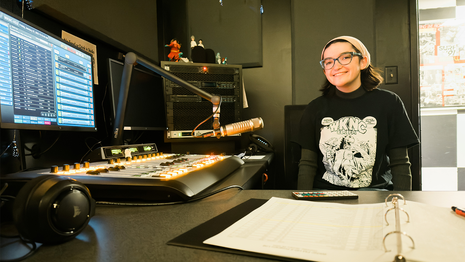 Caitlin Carroll sitting at a desk in one of WKNC's main recording studios