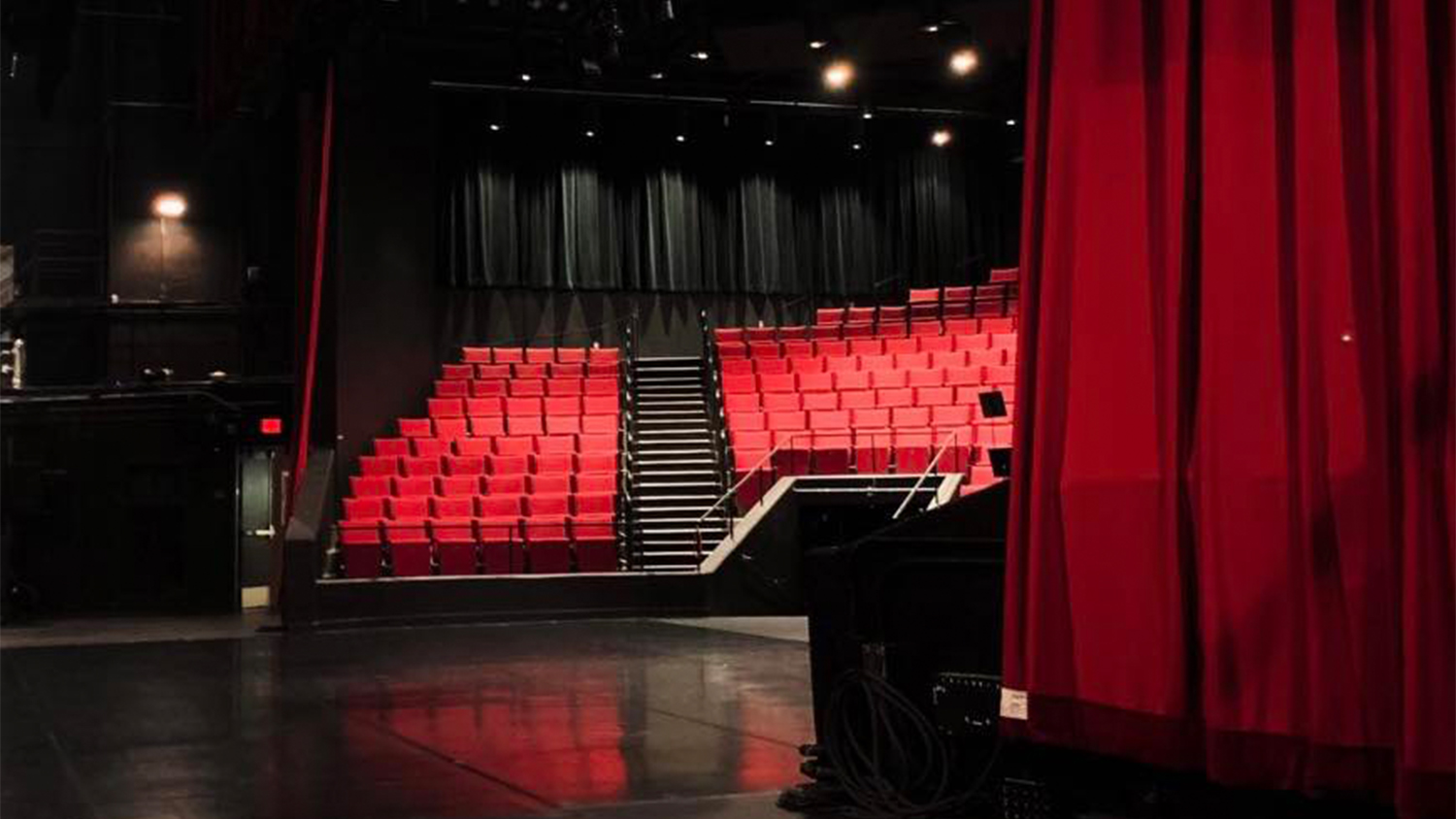 An empty stage behind a red curtain