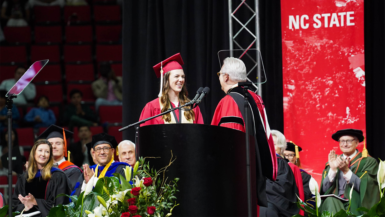 O'Connor shakes the Chancellor's hand as she climbs the stage to give the student address for the May 2023 NC State University Commencement Ceremony