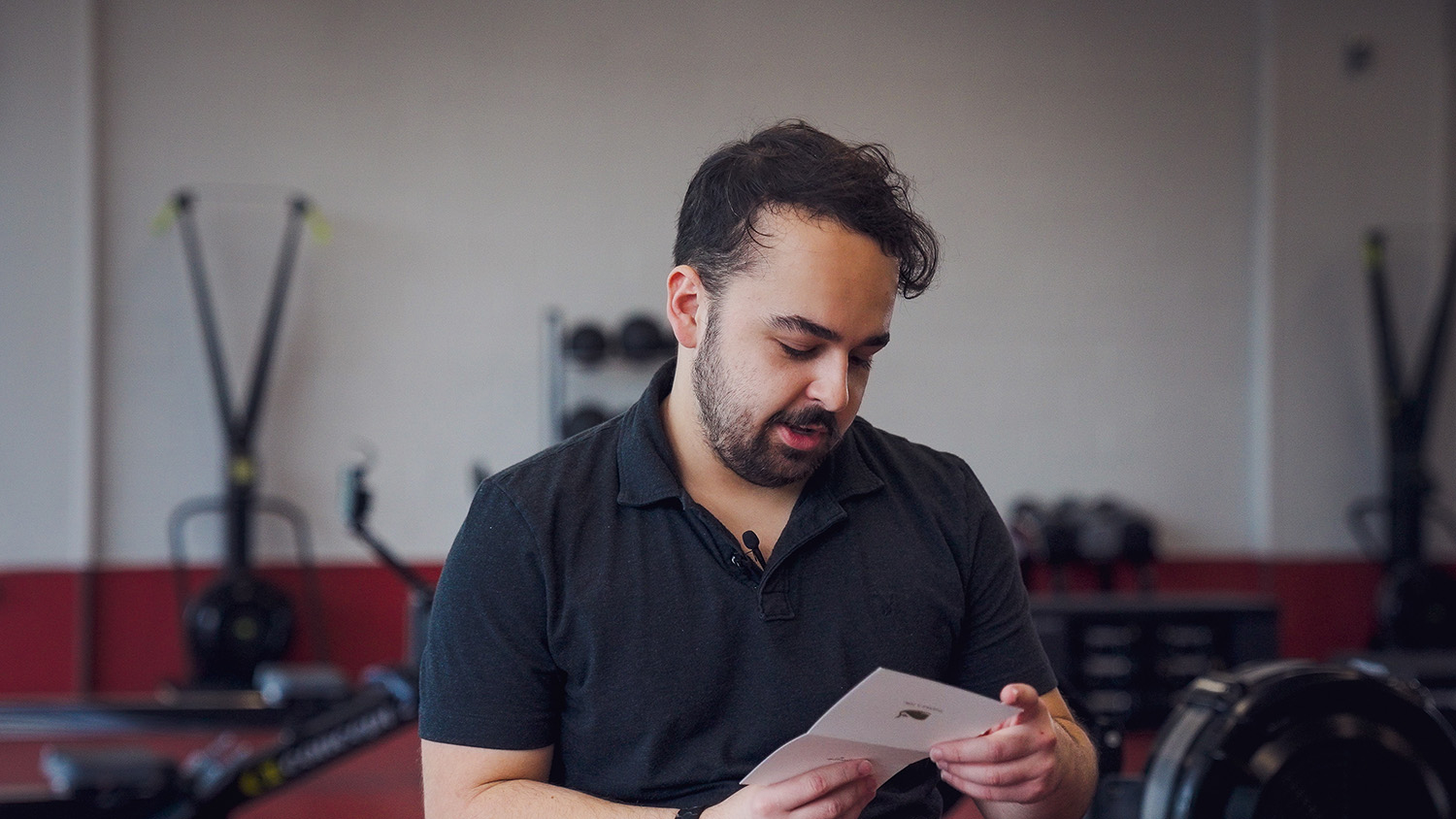 Ignacio Leon, a Wellness and Recreation Student Employee, reads a thank-you card from a patron whose life he helped save.