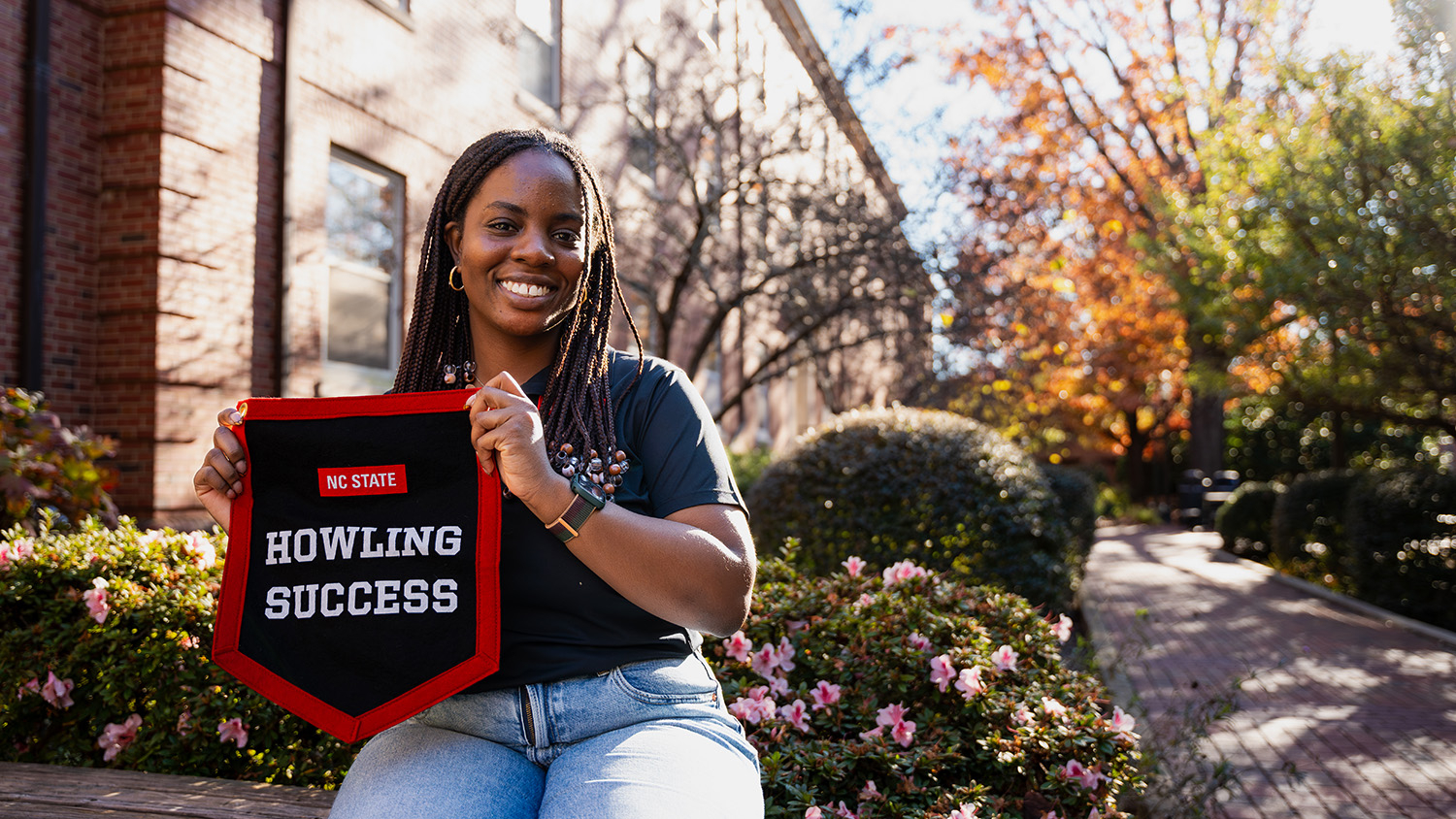 Ore Badejoh poses with her Howling Success banner on main campus.